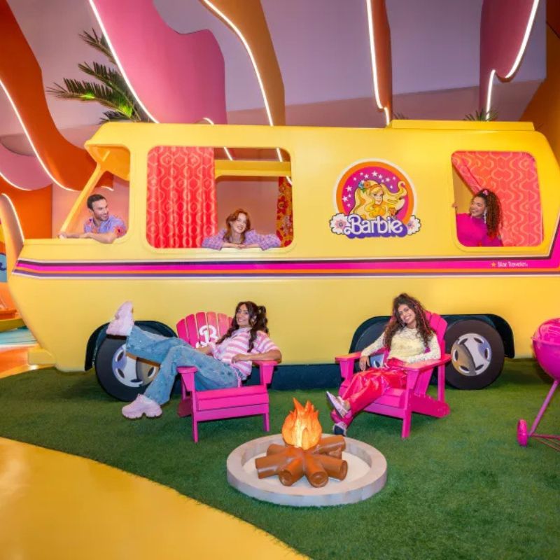 Visitors enjoying a colourful life-sized Barbie camper scene