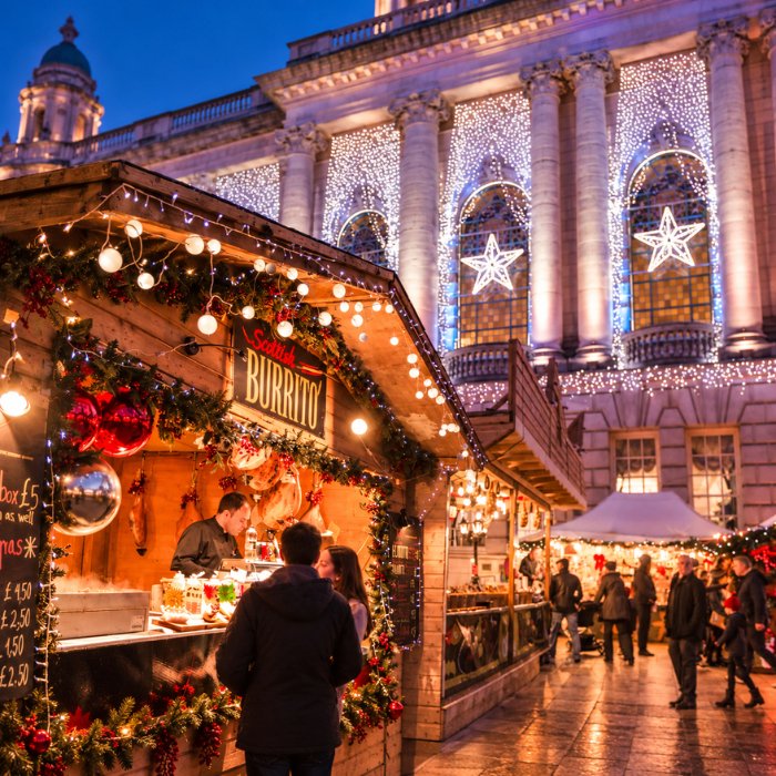Wooden Christmas market stalls decorated with garlands and warm lights