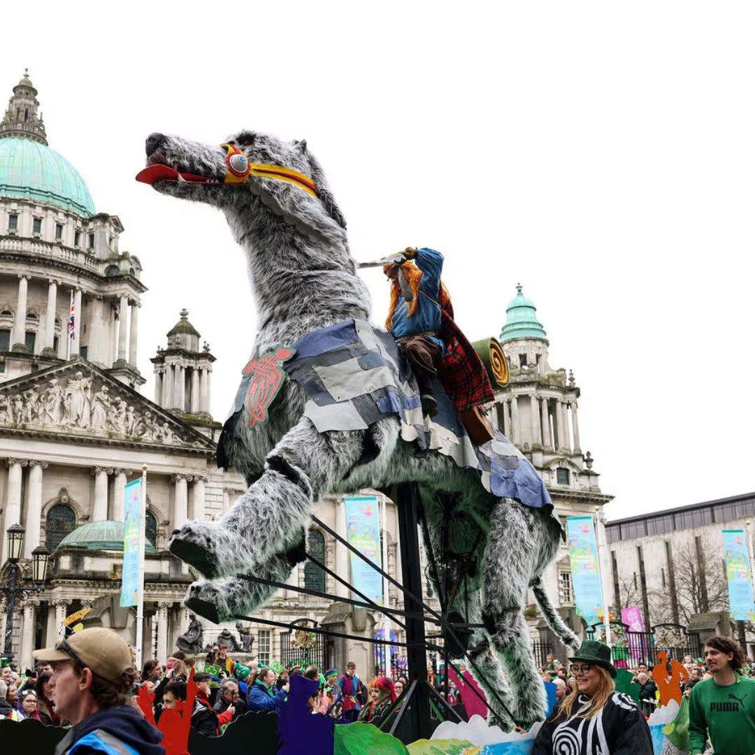A giant carnival puppet passing Belfast City Hall during St Patrick’s celebrations