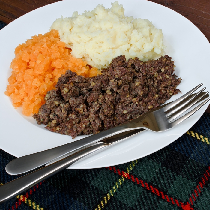 Traditional haggis, neeps and tatties pictured on a tartan table setting
