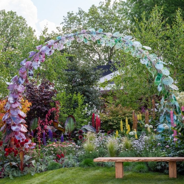 Colourful Chelsea planting beneath a sweeping sculptural arch