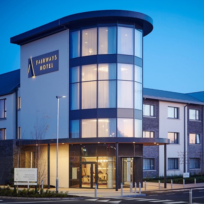 The illuminated entrance and modern exterior of the Fairways Hotel