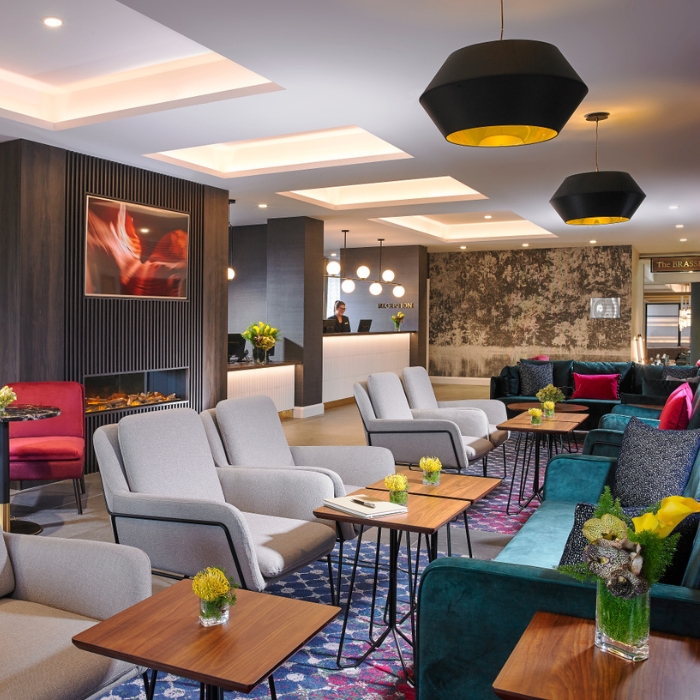 The Fairways Hotel's stylish lobby with colourful seating and a feature fireplace