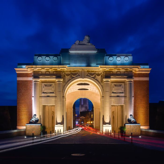 The Menin Gate memorial illuminated against the evening sky in Ypres