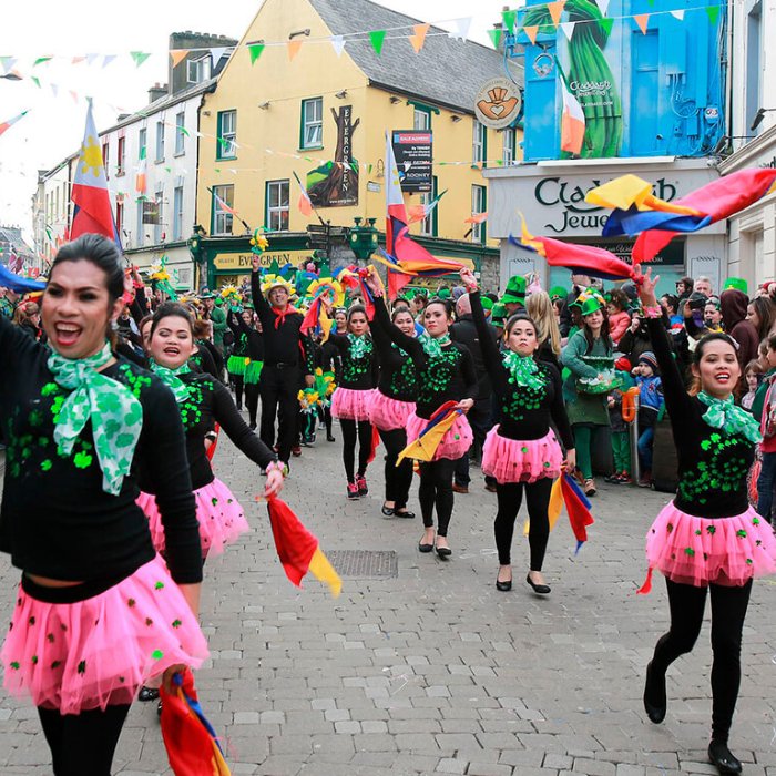 Colourfully dressed performers dancing through Galway during St Patrick’s celebrations
