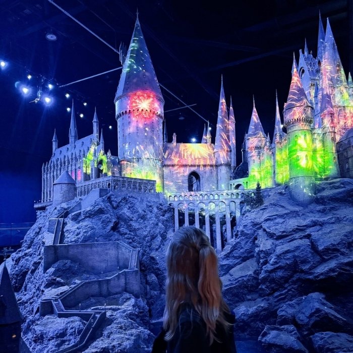 A visitor admiring the intricately detailed Hogwarts castle model