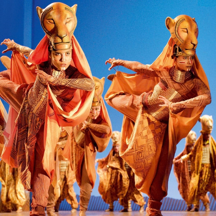 Performers in richly detailed lion costumes on stage