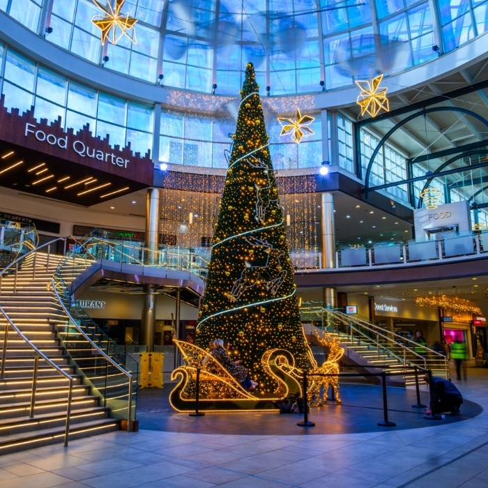A sparkling Christmas tree and golden festive lights inside Livingston Designer Outlet