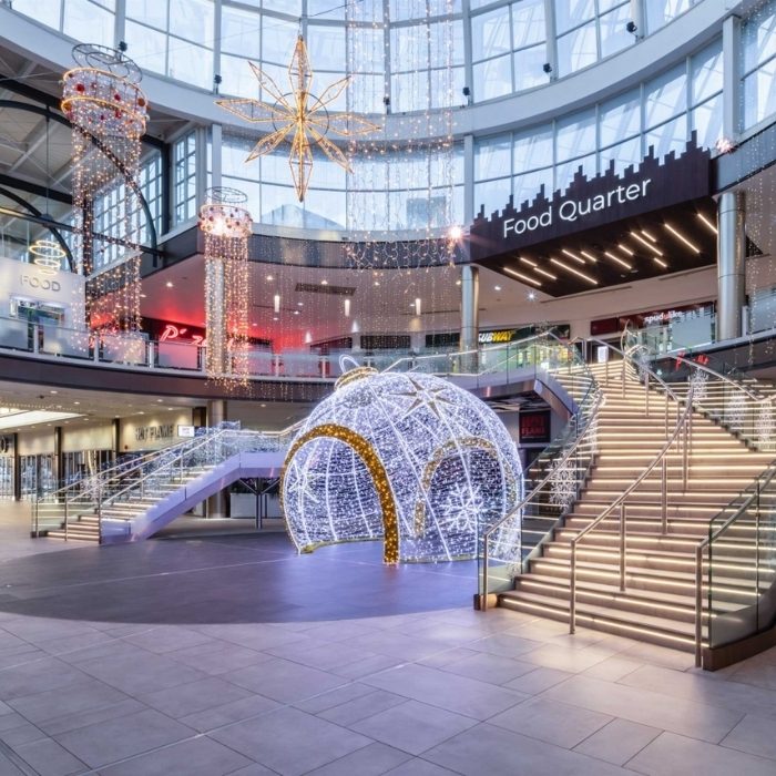 Glowing Christmas decorations beneath the glass roof of Livingston Designer Outlet