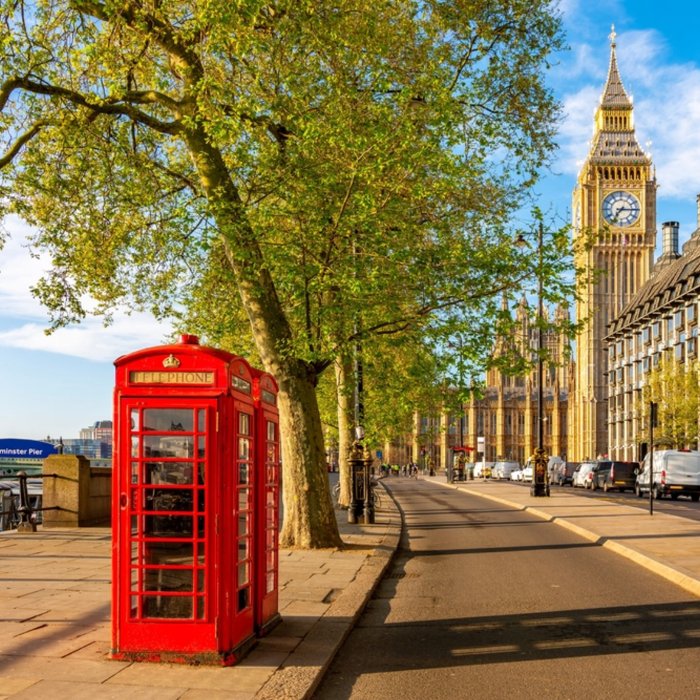 A red London telephone box with Elizabeth Tower and Big Ben beyond