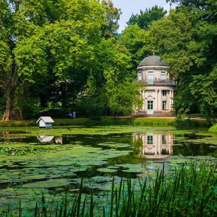 A garden pavilion reflected in a green pond at Pillnitz